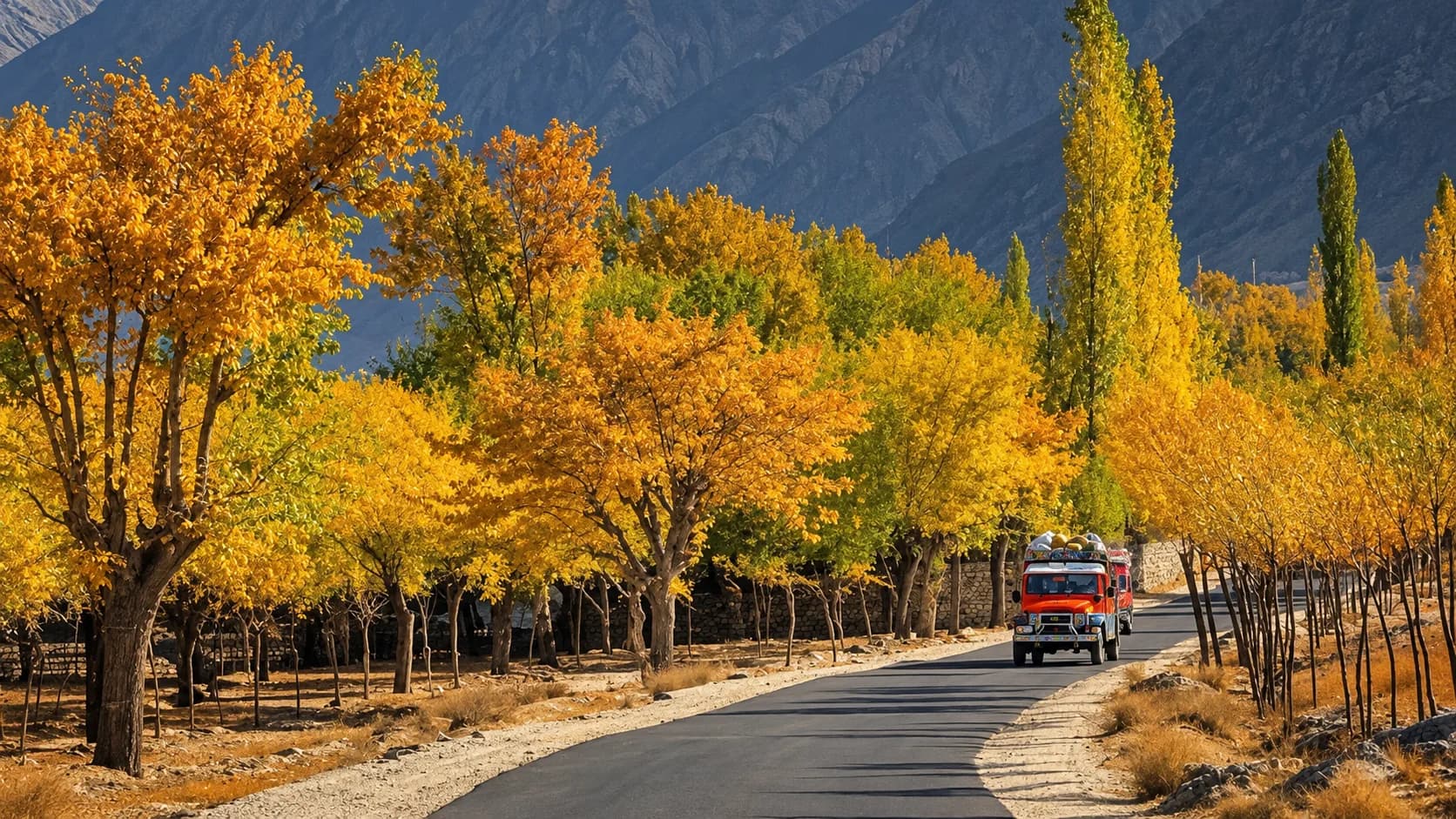 A traditional, brightly decorated truck driving on a smooth stretch of the Karakoram Highway during an autumn road trip, bordered by a vibrant canopy of yellow trees and overshadowed by dark, imposing mountain ridges in northern Pakistan.