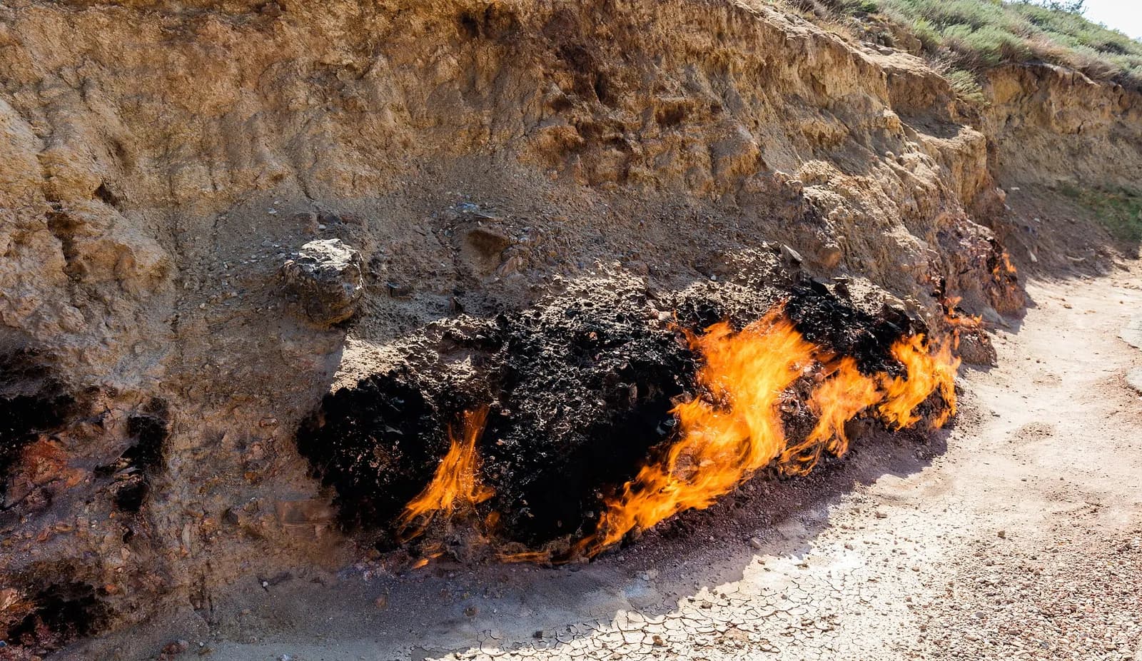 Natural gas flames burning along the foot of a sandstone bank at Yanar Dag on the Absheron Peninsula near Baku