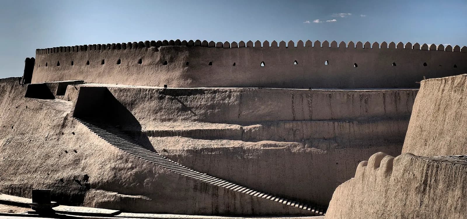 The crenellated mud-brick walls of the Itchan Kala, the walled old town of Khiva, Uzbekistan, with a long stair cut into the rampart